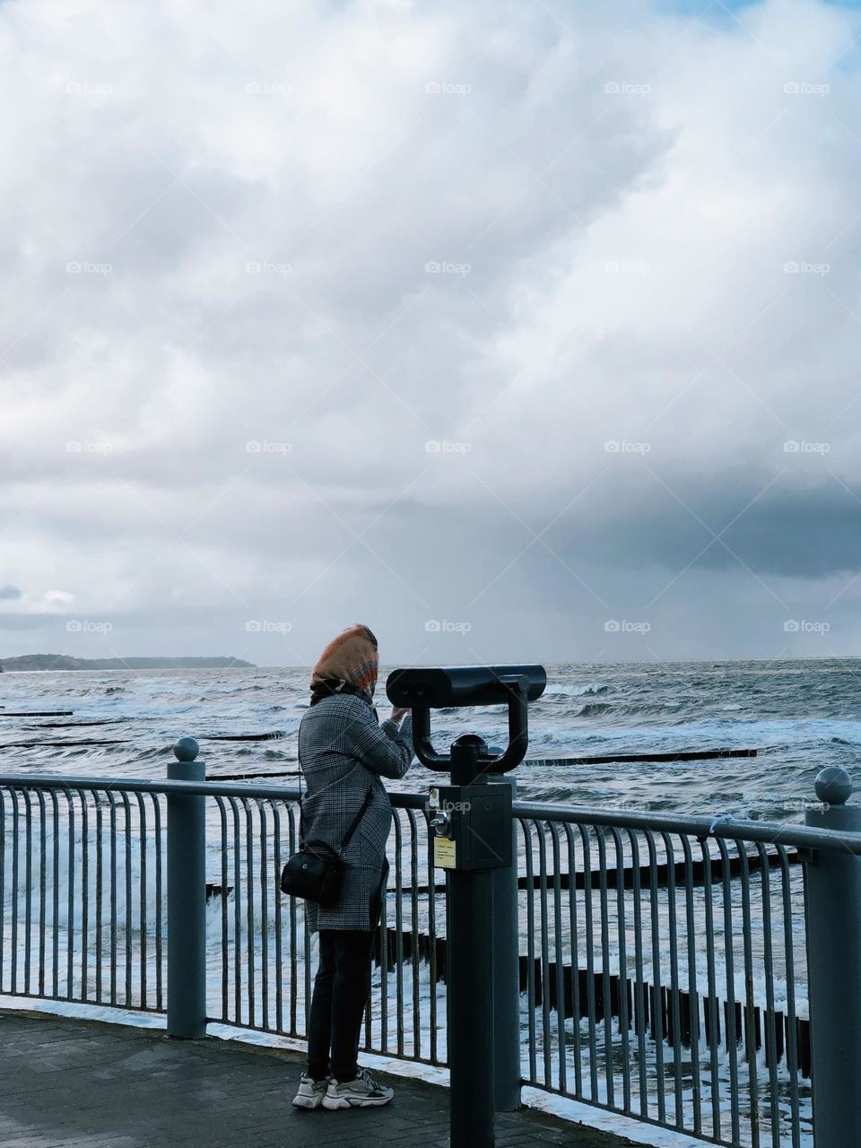 Unrecognisable woman near sea in autumn day 