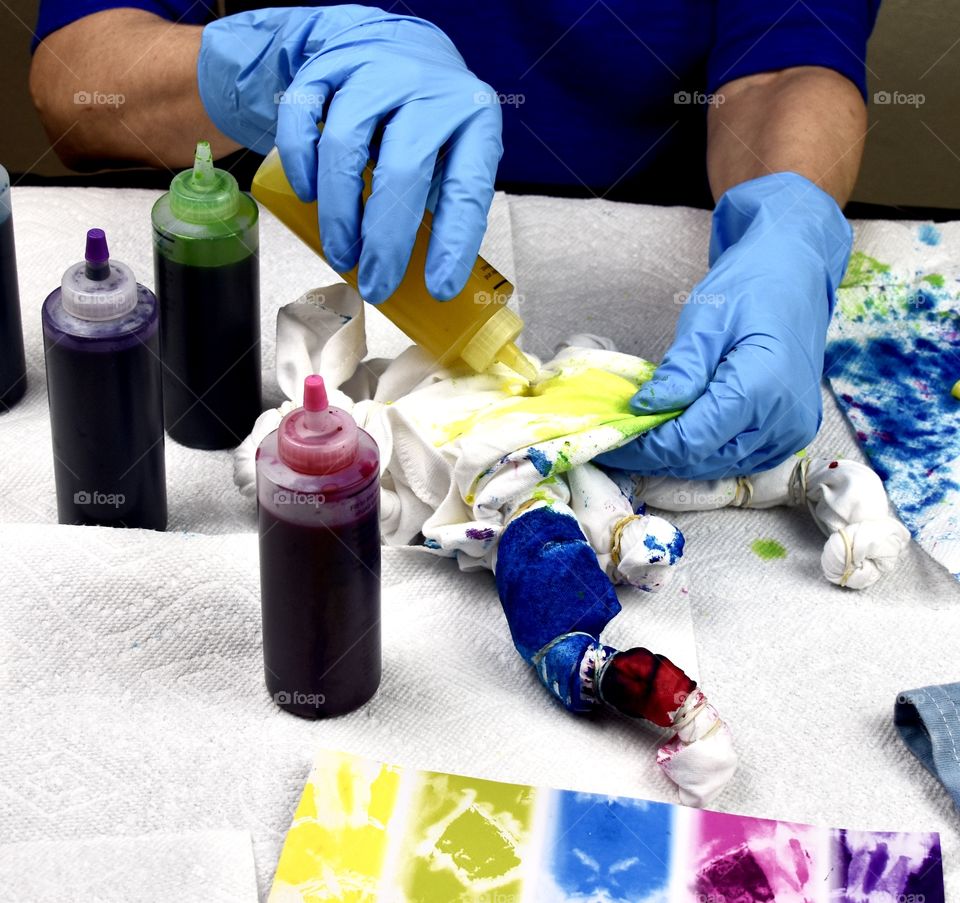 Tie-dying a cotton t-shirt while wearing Playtex disposable blue gloves 
