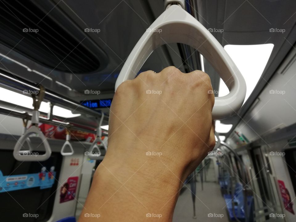 Hand is held on the handle of the subway