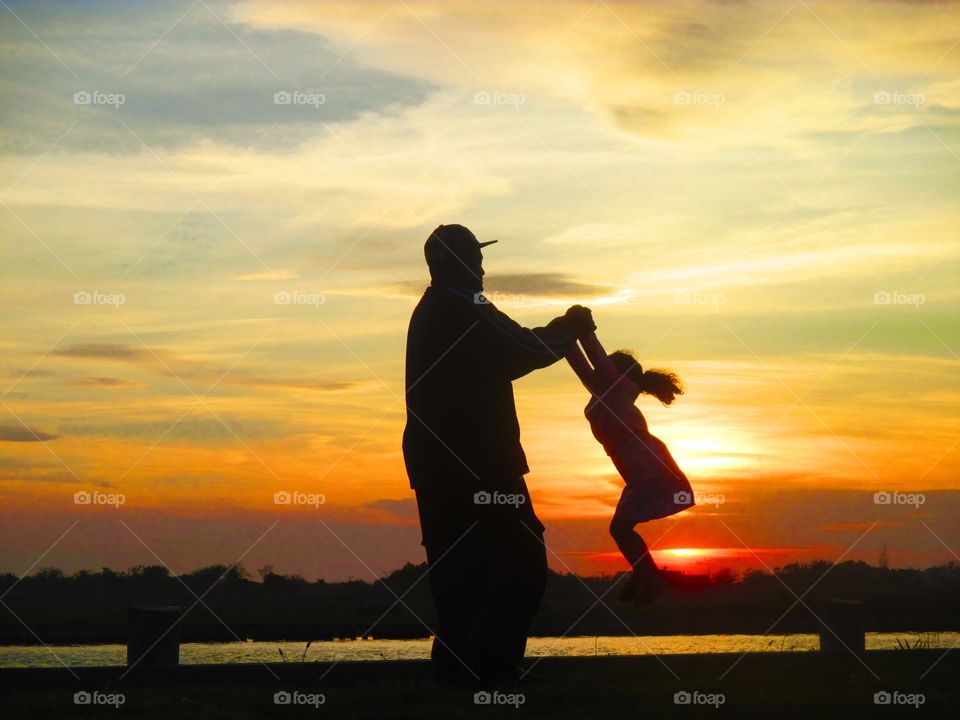 Father and daughter dancing in the sunset 