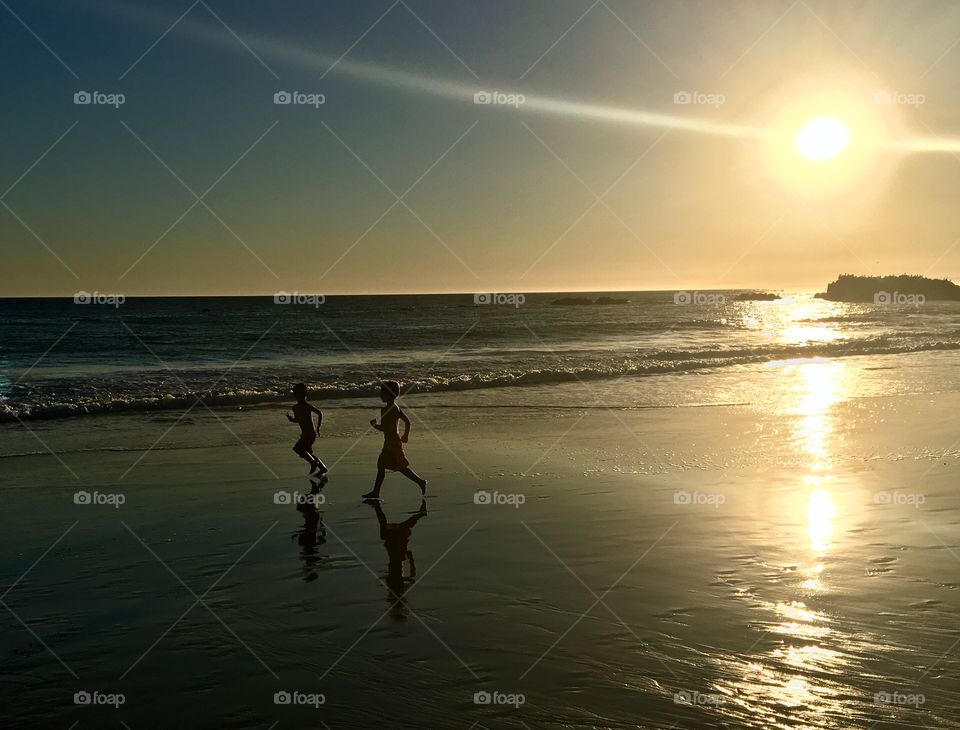 Kids running along the beach.