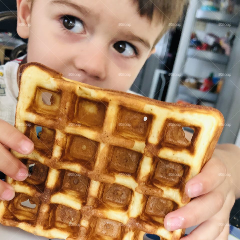 Toddler having waffle for breakfast