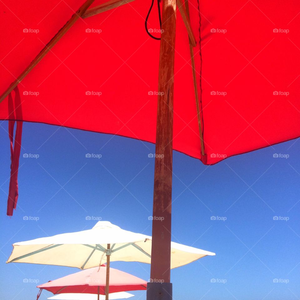Beach umbrellas . Three color umbrellas against the blue sky at the beach