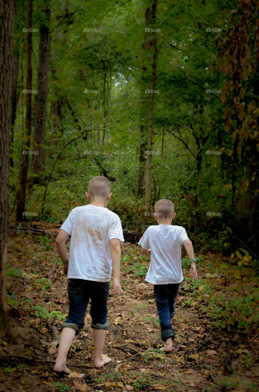 Two boys walking in the woods