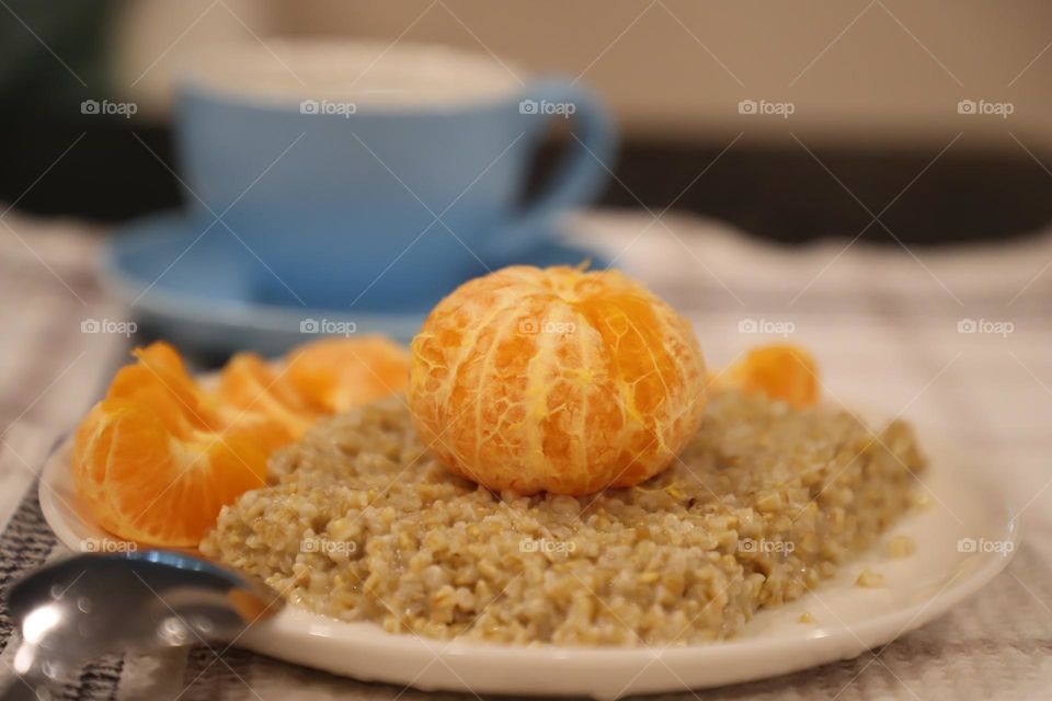 Plate with oatmeal and mandarin on top- healthy eating 