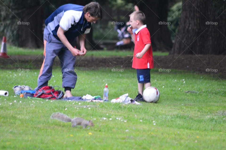 Father and son seen to spend free time together, next to close sneaking squirrel