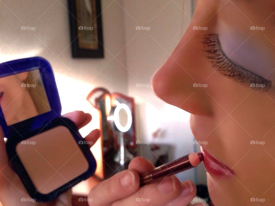 Woman applying cosmetics.