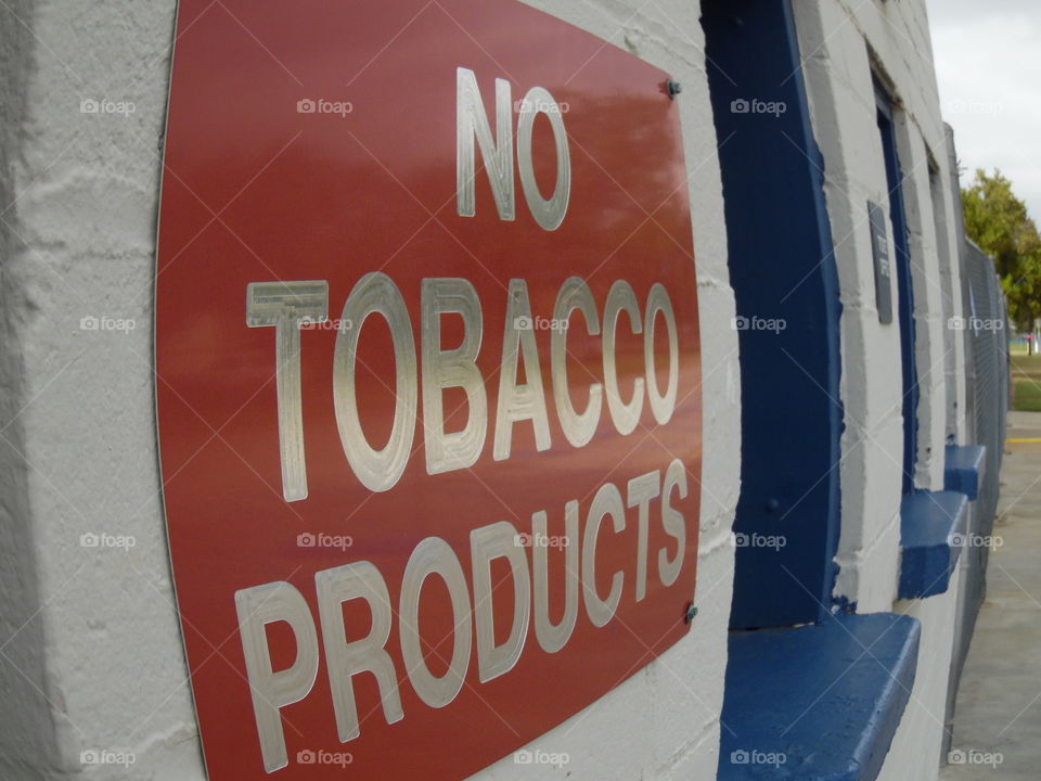 no smoking 🚬. This is a picture of a sign displayed on the side of the concession stand.