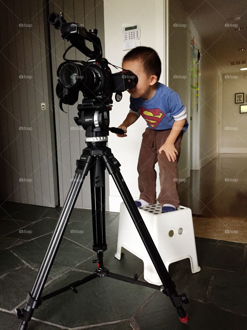 Toddler sets up a shot on his movie camera.