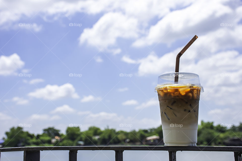 Glass of cold espresso coffee on the iron balcony Background views of the river and the home.