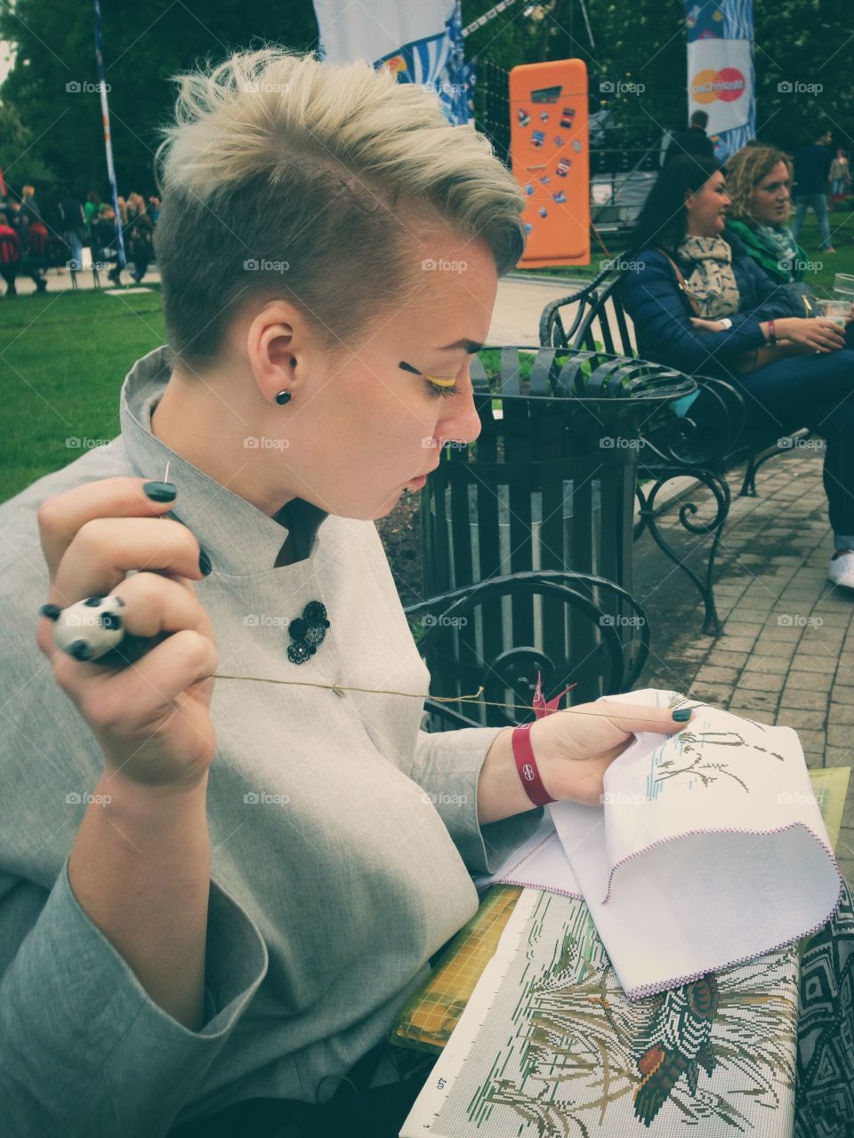 Woman with a panda ring on the hand knitting on the street on Bosco fresh fest music festival in Moscow, Russia