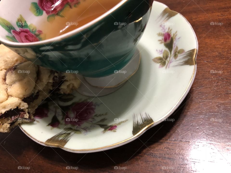 Tea cup with partially eaten cookie next to it