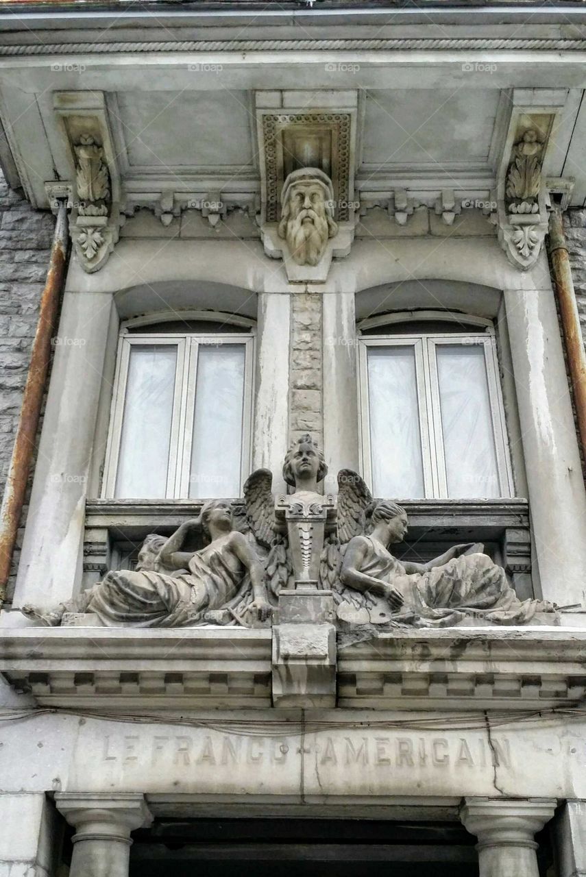 Stone statues over an entrance of a old building in Montreal