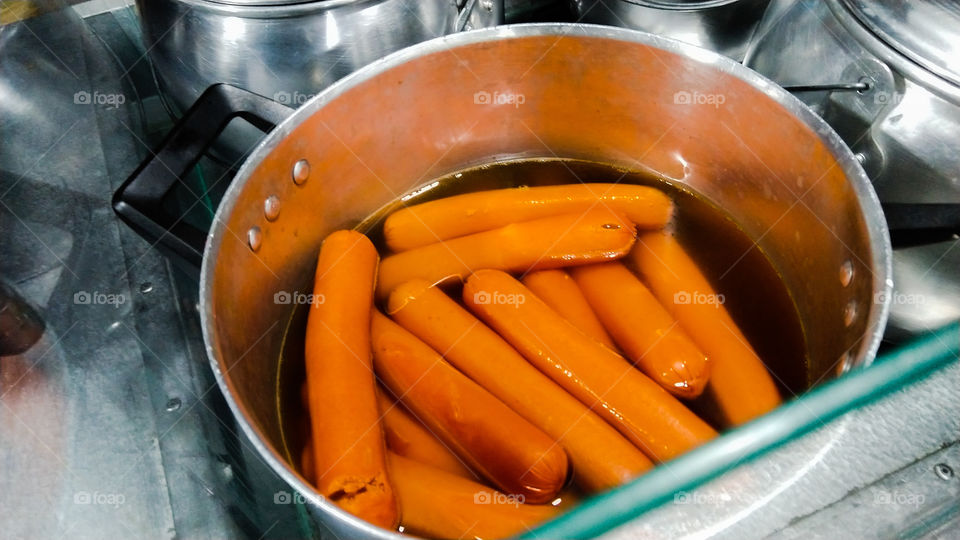 Salsichas em água quente para preparo de cachorro quente.