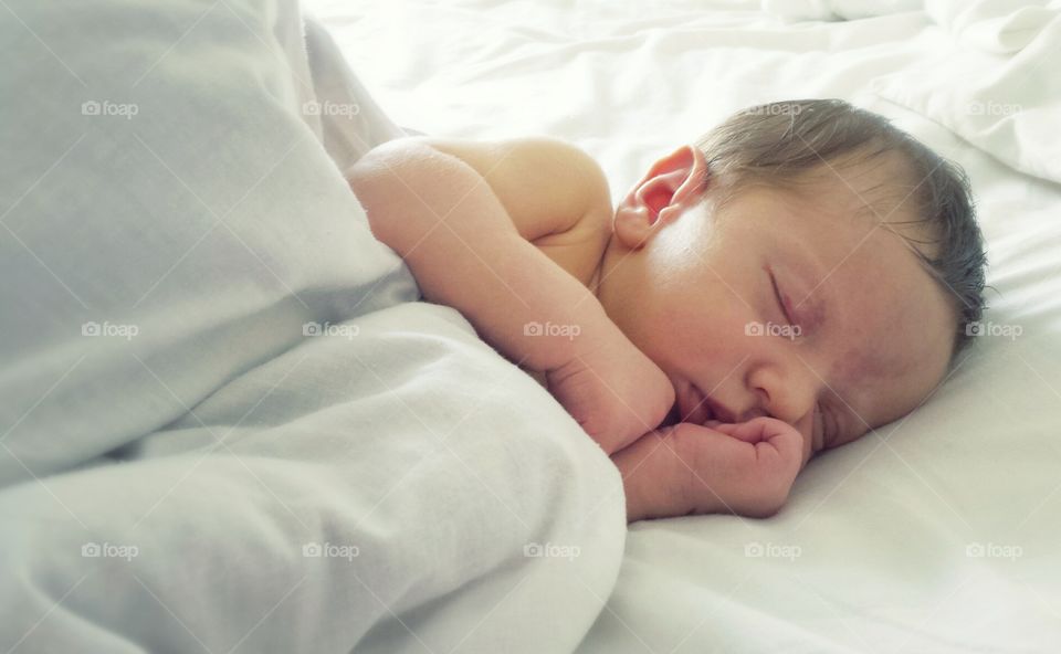 Newborn baby sleeping on white blankets / baby white background