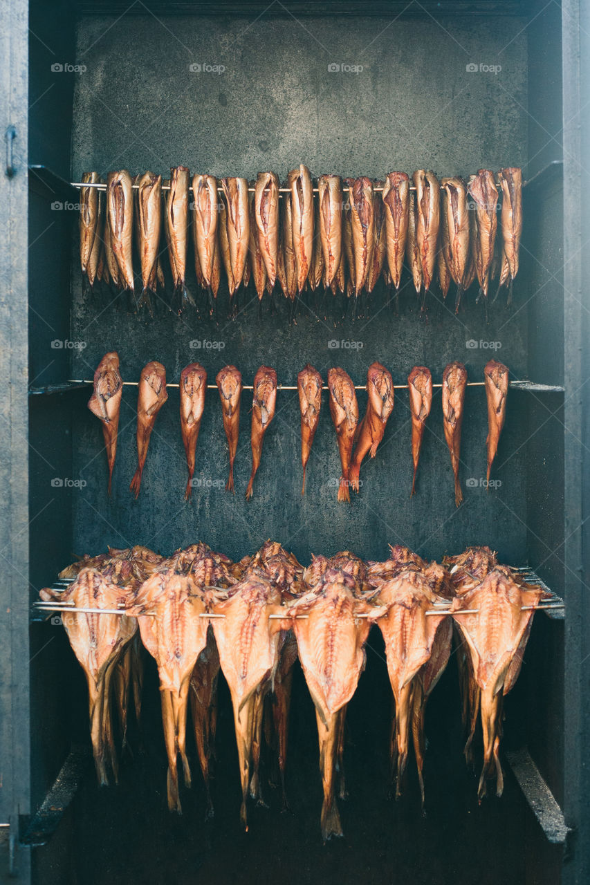 Rows of fishes in smoking chamber. Close up of smoking process of fresh fishes