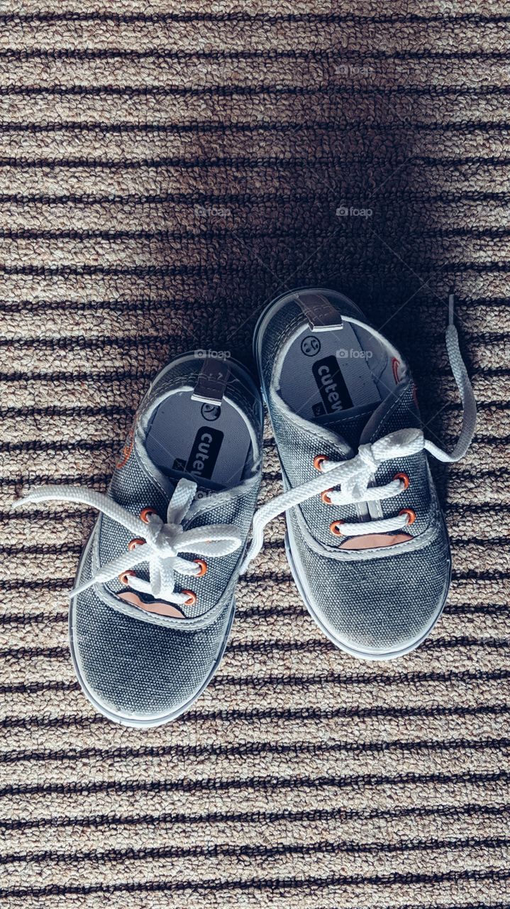 two year baby boy shoes on carpet