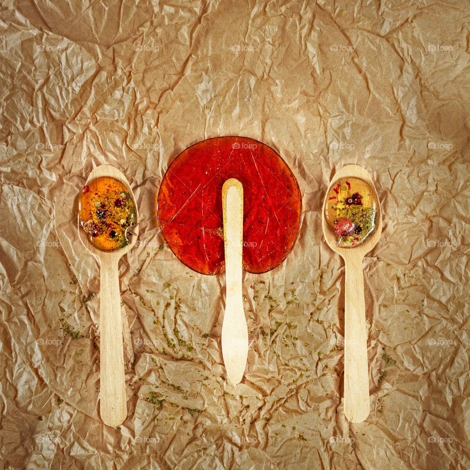 Useful sweetness. Lollipops are made at home from natural ingredients on wooden spoons and a stick on crumpled Kraft paper. Concept of environmental products and consumption without plastic