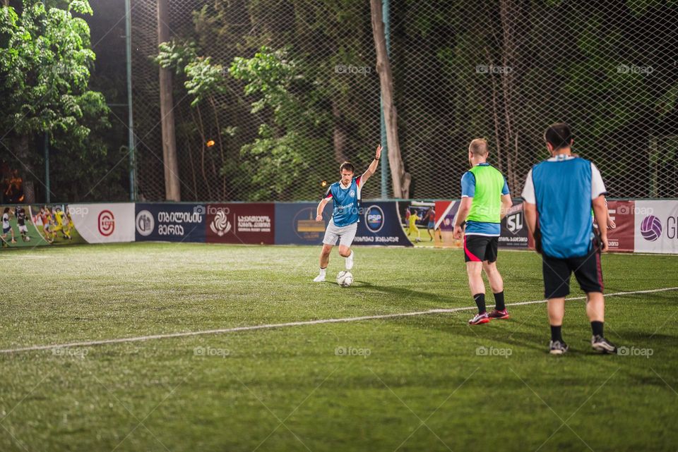 Football player kicking the ball on a football field