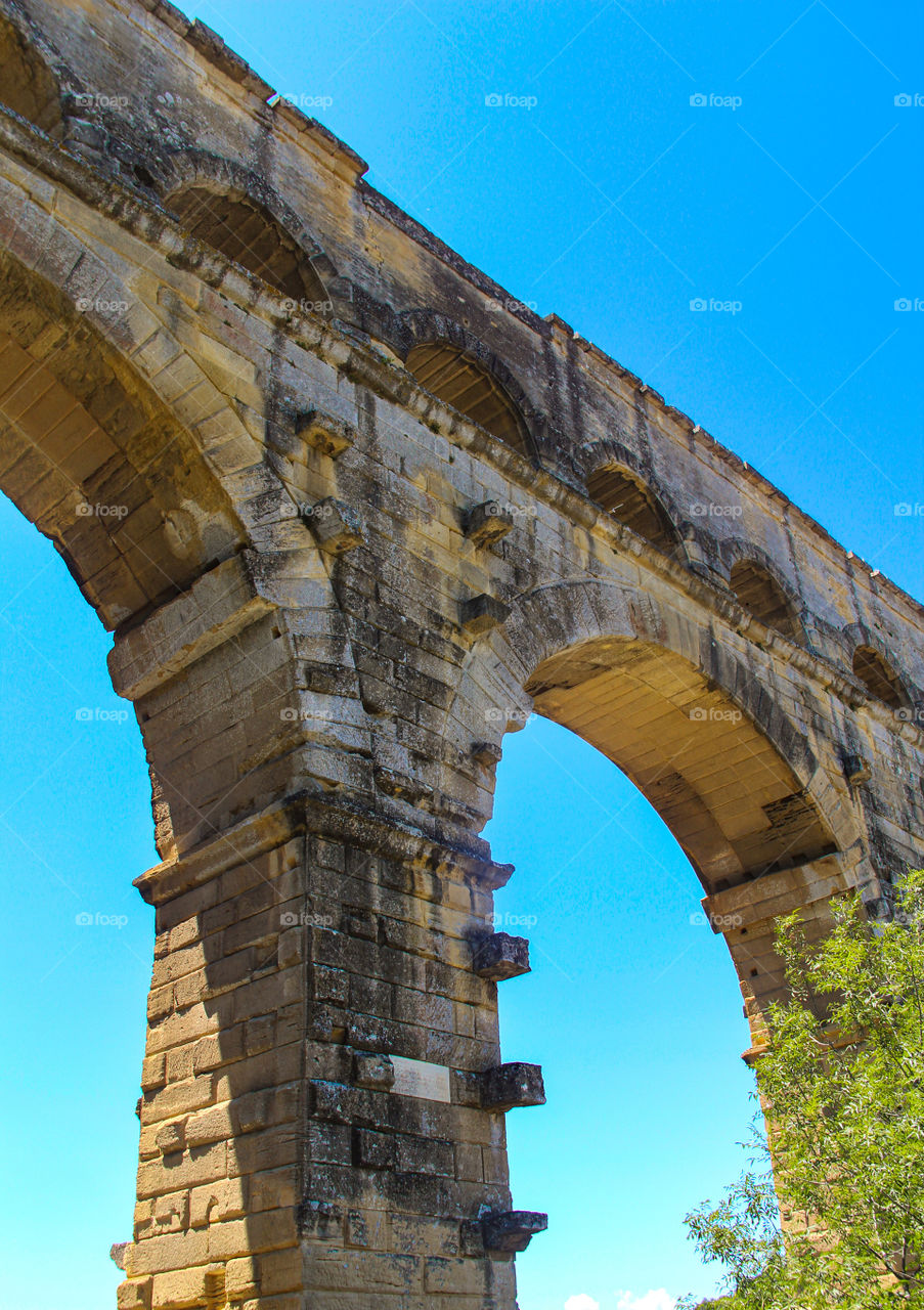 A bridge made of stone against a blue sky