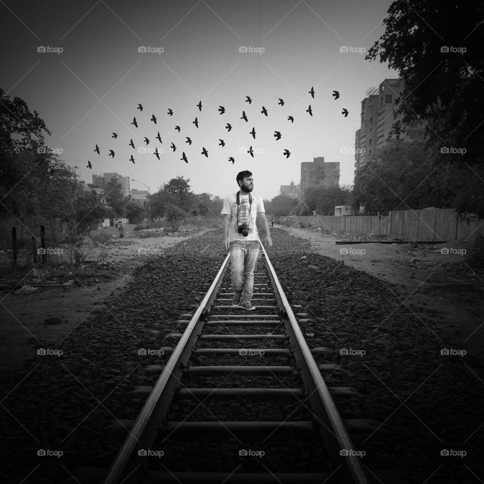 Male photographer walking on railroad track
