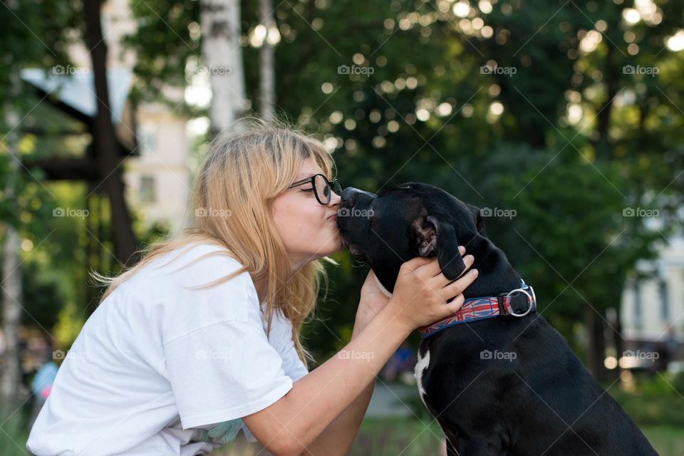 walking the dog down the street, the owner walks the weakling, teaches her, cleans up after her, educates, plays with his pet. people and dogs are best friends