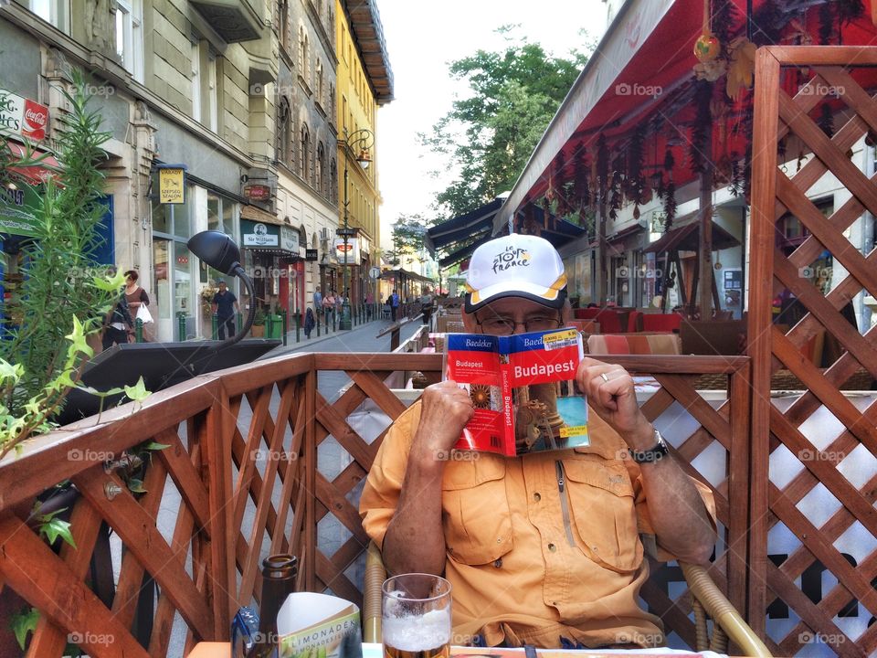 Man reading Budapest travel book