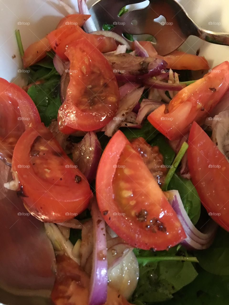 Spinach, beefsteak tomatoes, and red onion salad, with balsamic reduction