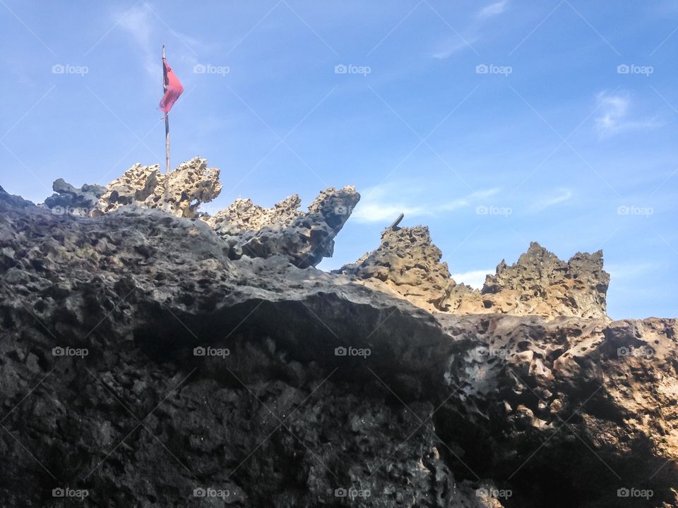 the flag fluttered on the rock by the beach.