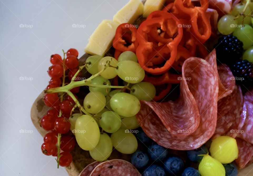 Fruits, cheese and meats on the plate