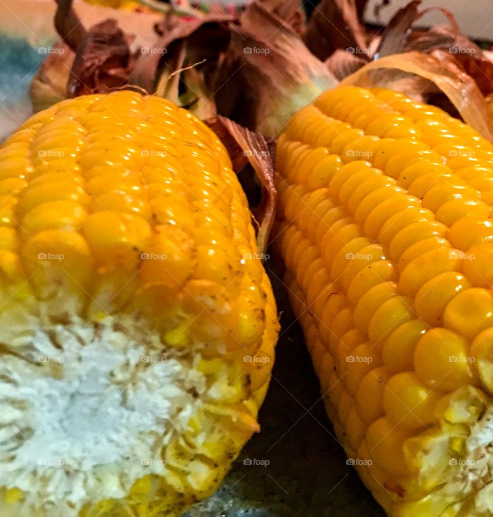 Close-up view corn on the cob roasted corn cobs with husk buttery delicious 