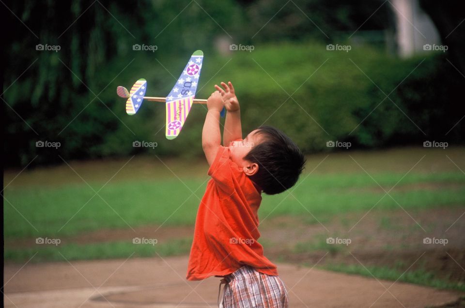 Japanese boy catches paper airplane in a park near Tokyo, Japan 