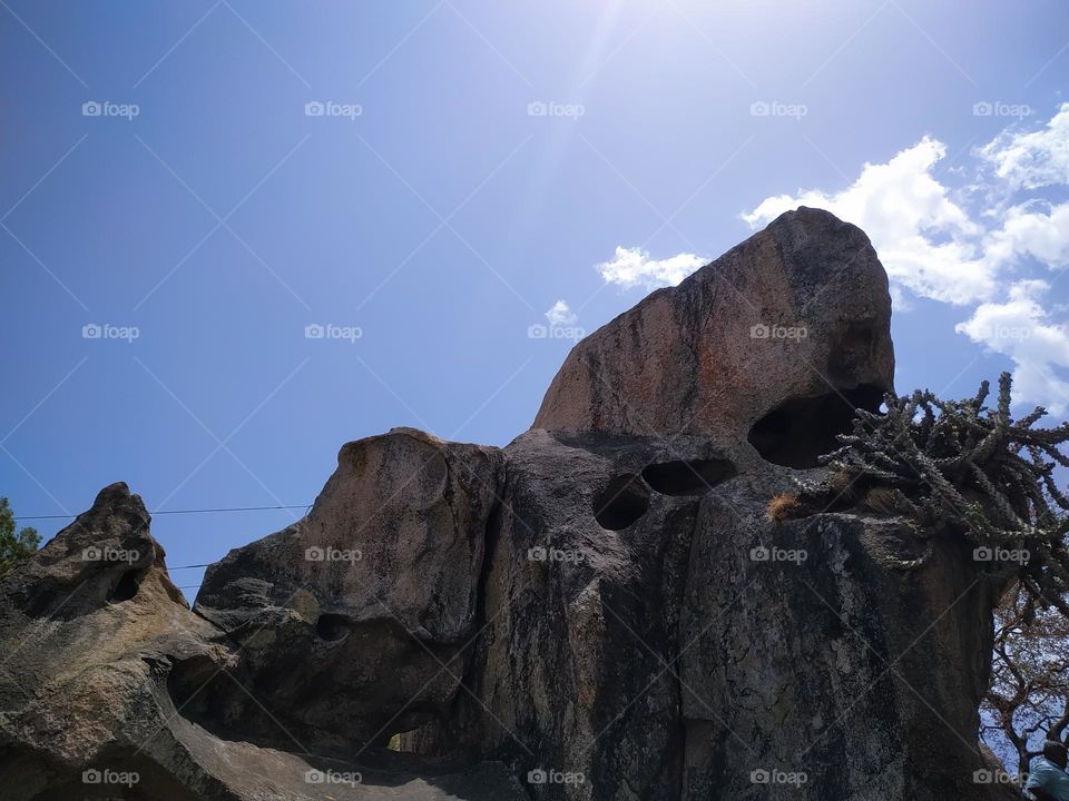 A rock in the mountains with blue sky and cloud