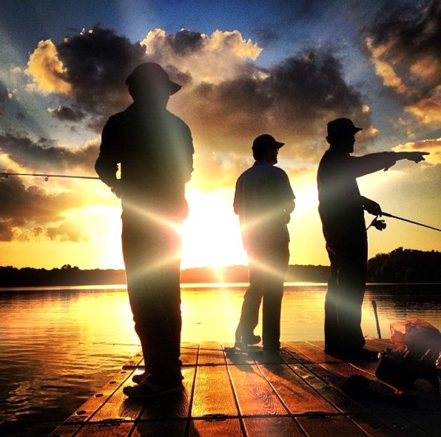 Silhouette of man fishing in the lake