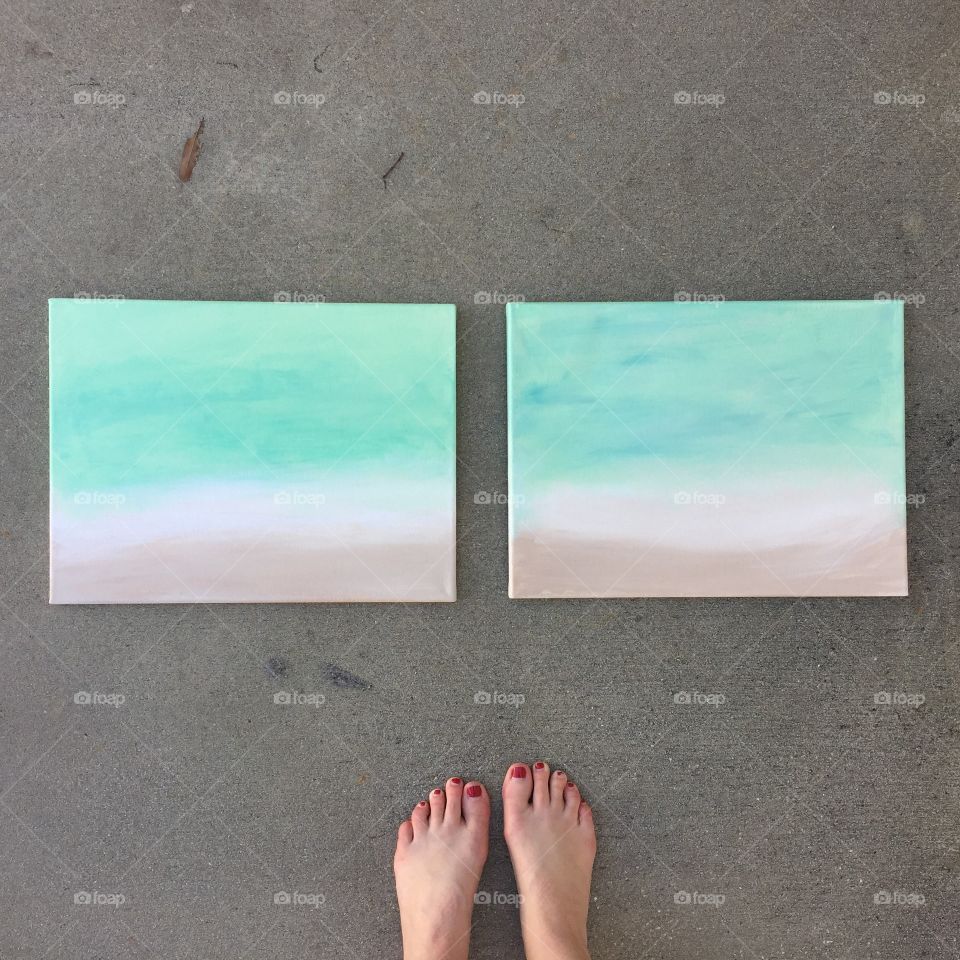 Low section of woman standing near painting at beach