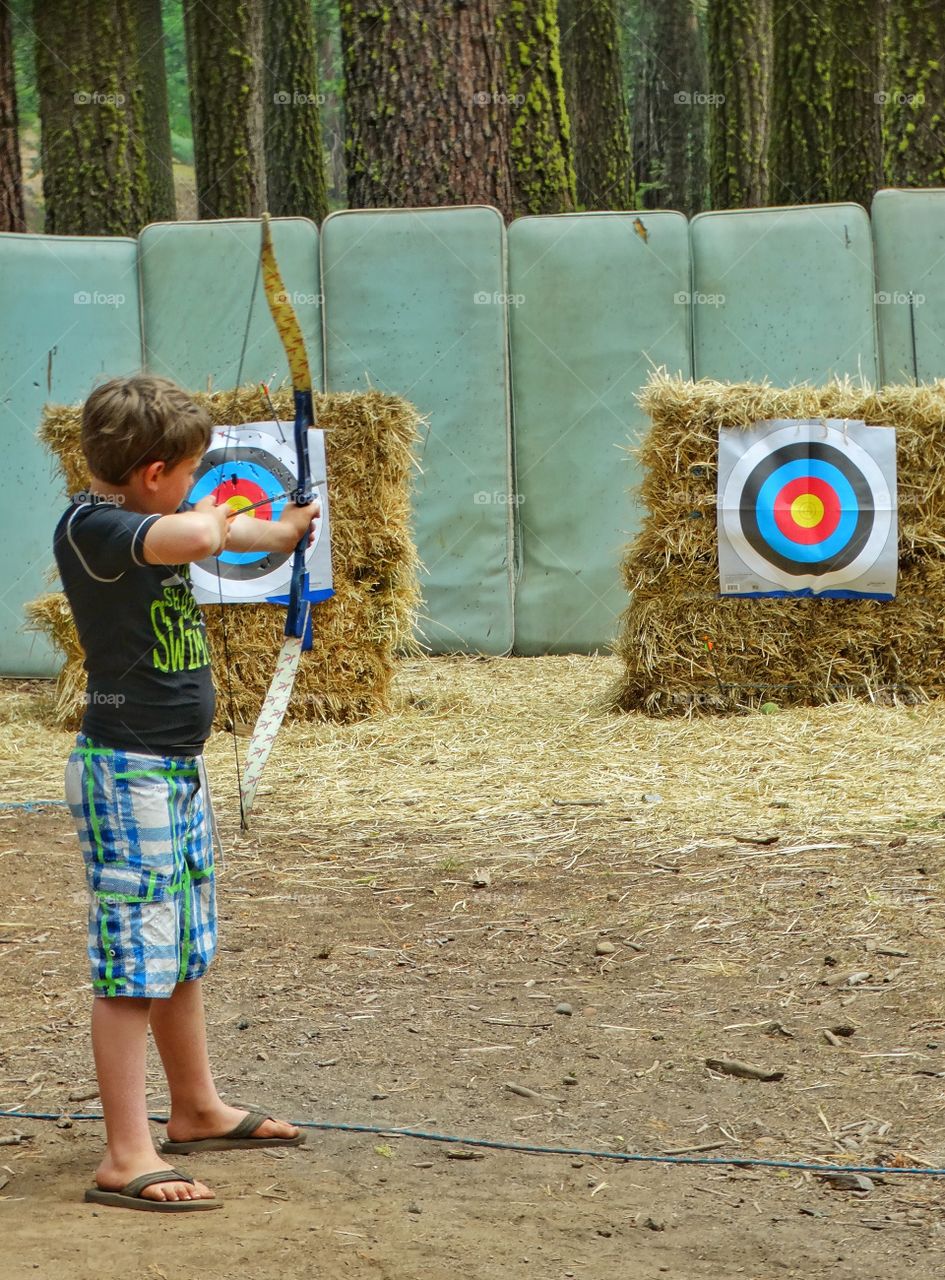 Archery Range. Boy Shooting Arrows At A Target
