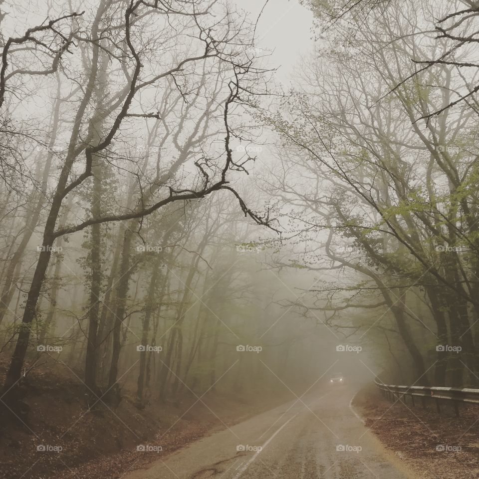 Empty road against foggy sky
