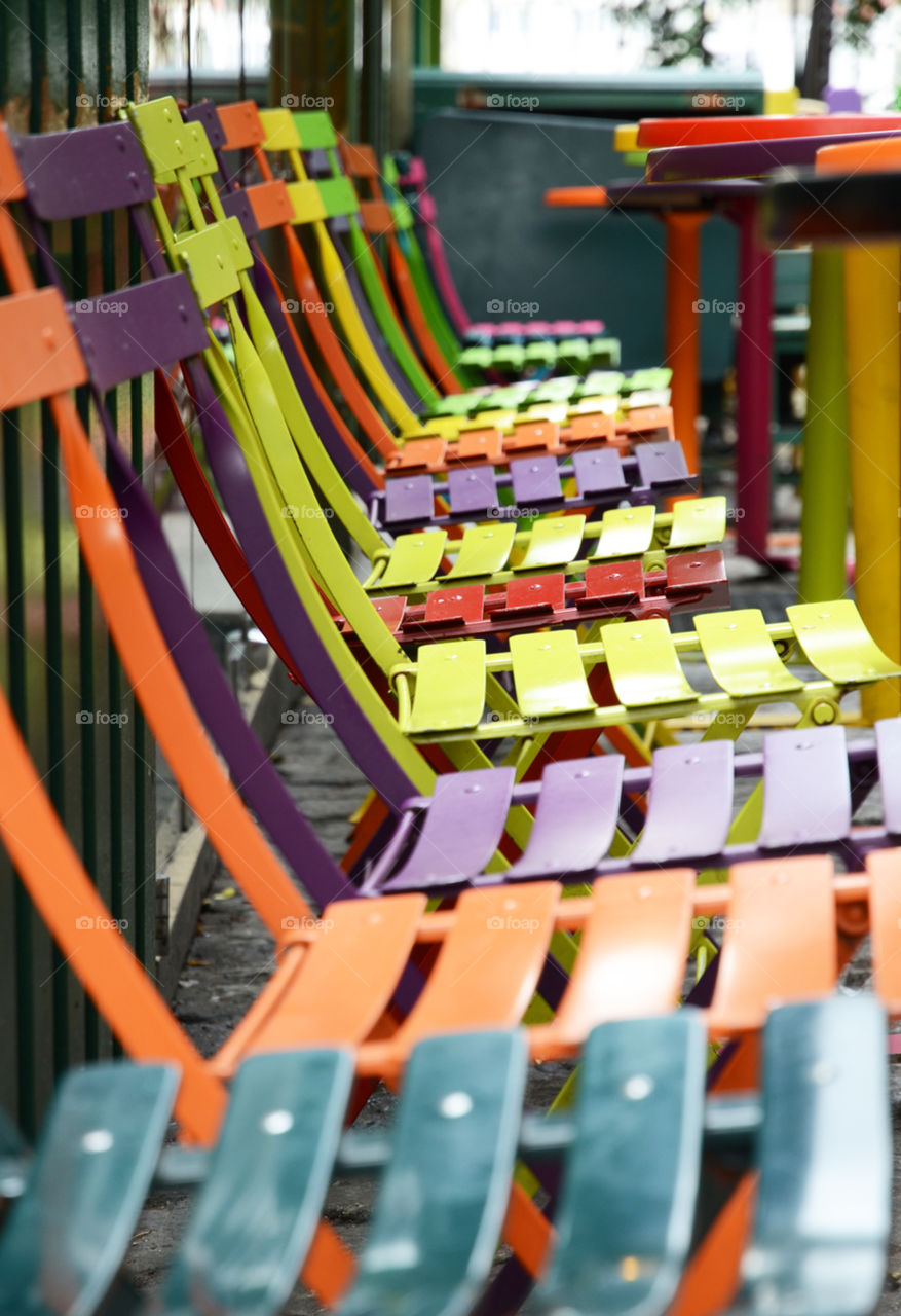 Colorful chairs at an outdoor cafe in Paris, France