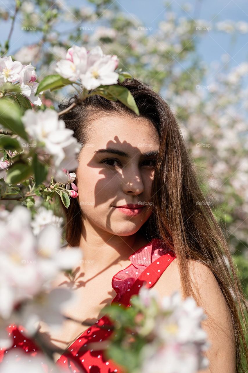 woman in red dress in apple blossom