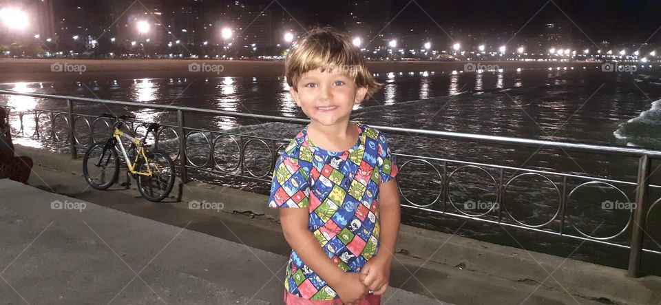 blond boy on the beach at night in Santos