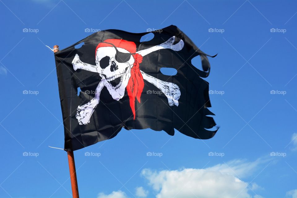 A Jolly Rodger pirate Flag blows in the wind. 