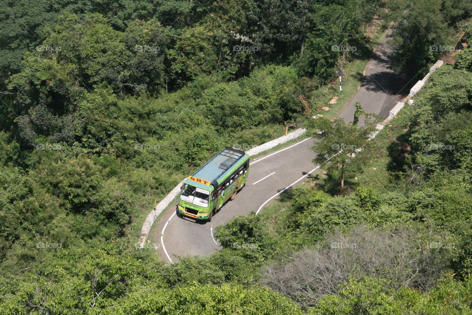 bus taking its turn in a hill road