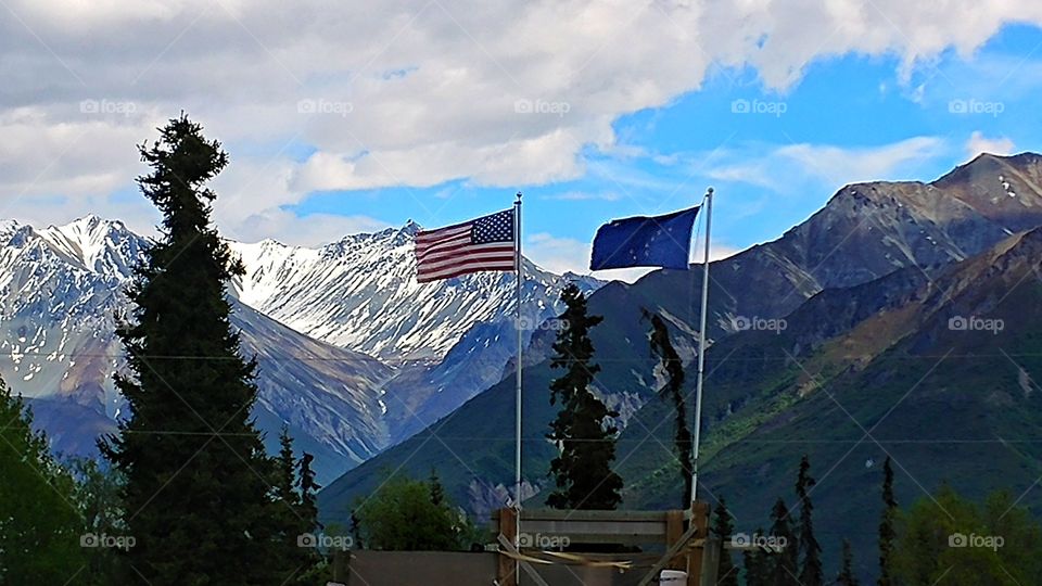 American a,d Alaskan fly proudly in Alaska's majestic mountains.