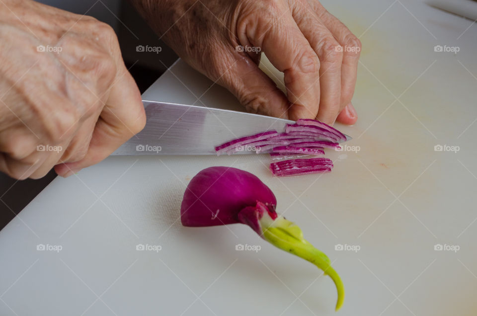 slicing a red onin to add a salad.