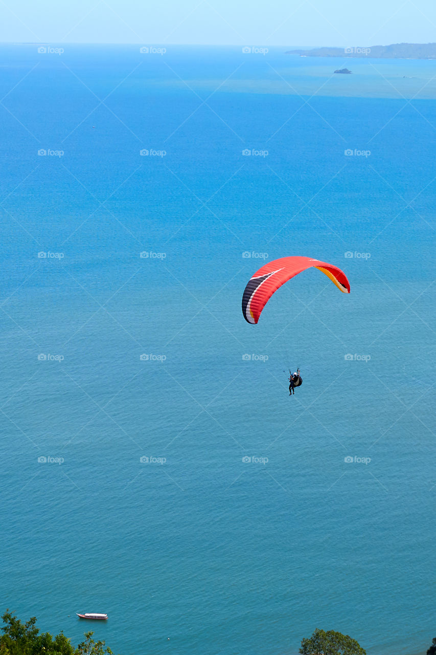 people fly with parachutes with beautiful ocean views