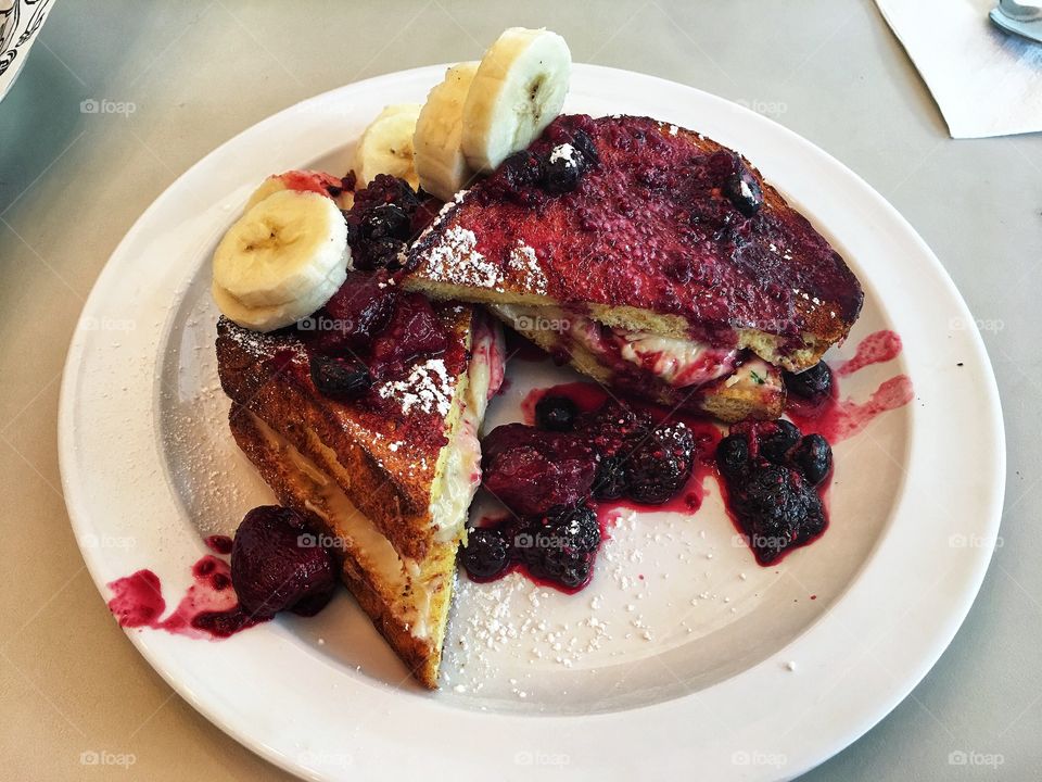 Stuffed french toast with warm berry compote and bananas