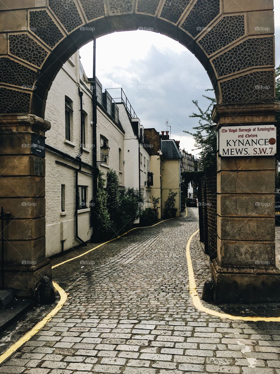 A Mews Street in London. Cobblestone through an archway. 
