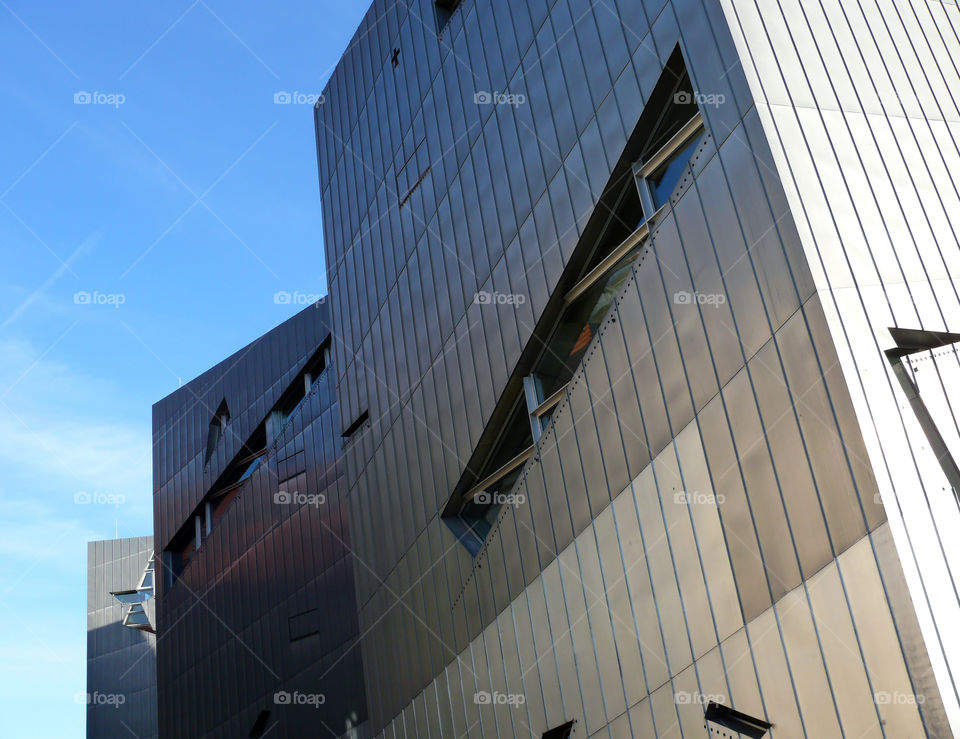 Low angle view of building exterior of the Jewish Museum Berlin against blue sky.