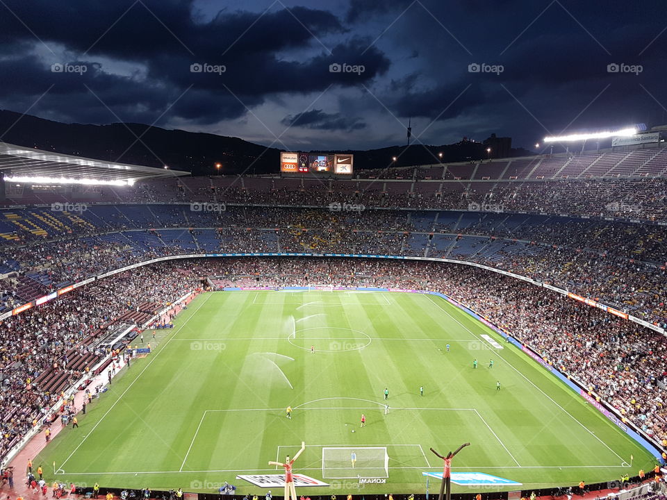campnou noucamp Barça barcelone barcelona  stadium match soccer foot football. The construction of Camp Nou started on 28 March 1954 as Barcelona's previous stadium,Camp de Les Corts, had no room for expansion. Although originally planned to be called "Estadi del FC Barcelona", the more popular name "Camp Nou" was used. The June 1950 signing of László Kubala, regarded as one of Barcelona's greatest players, provided further impetus to the construction of a larger stadium.[5][6][7]

The architects were Francesc Mitjans and Josep Soteras, with the collaboration of Lorenzo García-Barbón.[8]

Early years and the 1982 World CupEdit

In May 1972, Camp Nou hosted its firstEuropean Cup Winners' Cup final betweenRangers and Dynamo Moscow. Rangers won the match with a score of 3–2. The 1970s marked a turning point for Barcelona with the signing of a new player, Johan Cruyff, in 1973. Electronic scoreboards were installed in the stadium two years later.

The stadium underwent an expansion in 1980, in anticipation of the 1982 FIFA World Cup, which added boxes, VIP lounges, a new press area, new markers and the construction of the third tier, which was however smaller in height than the original design by 6 meters, 46.60 meters compared to the original design of 52.50 meters. The expansion of the stadium added 22,150 new seats,[9] taking the total seating capacity to 71,731, and the standing capacity was expanded by 16,500 to 49,670, taking the total stadium capacity (seated and standing combined) to 121,401.[10] FC Barcelona's record attendance was set on 5 March 1986 in the European Cup quarter final against Juventus in front of 120,000 spectators, just 1,401 shy of the stadium's capacity.
