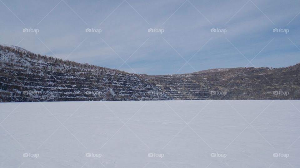 The walls of the Zavitinsky lithium Deposit quarry, flooded with groundwater.